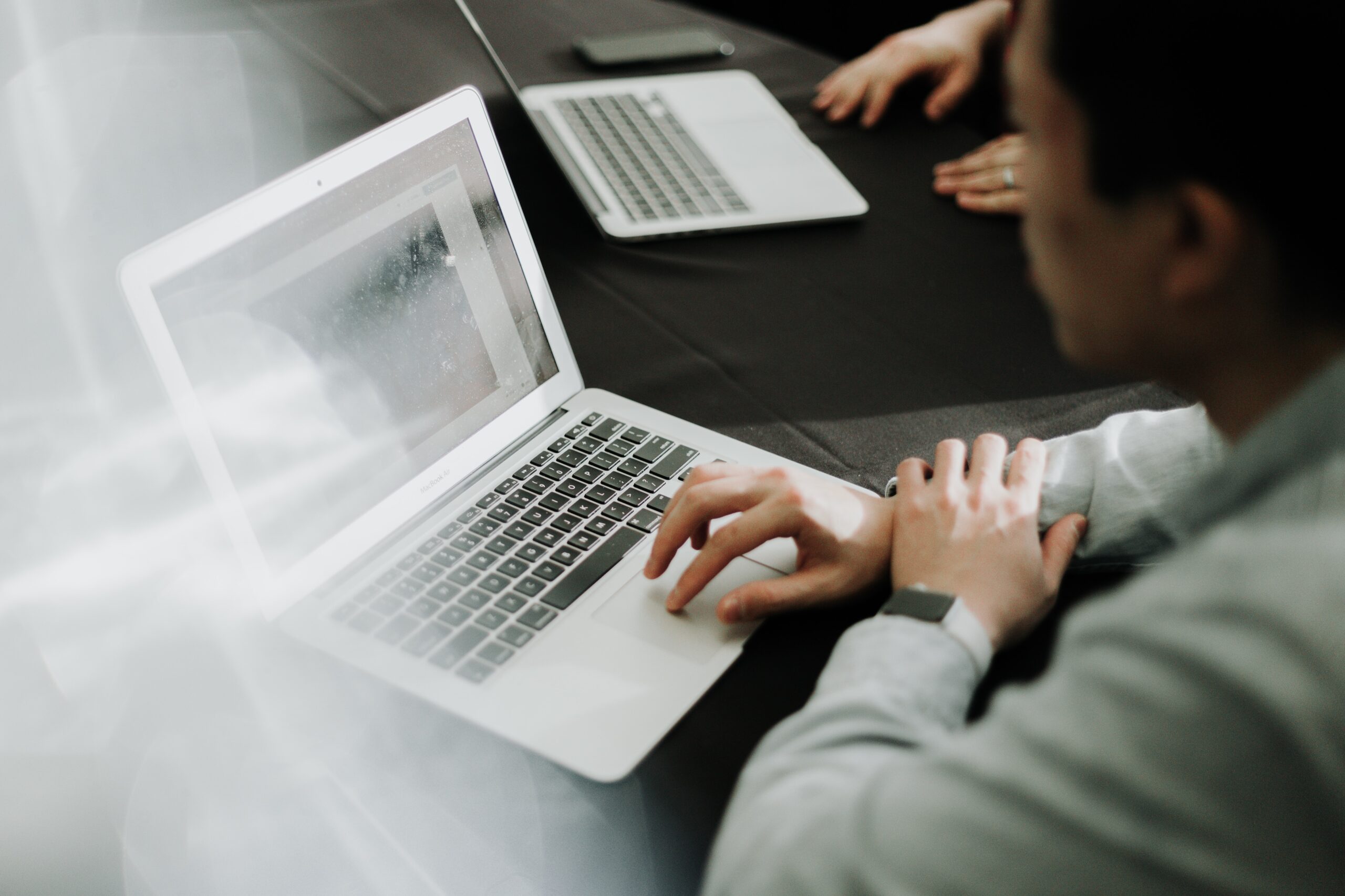 man in white suit reviewing his finances on a laptop